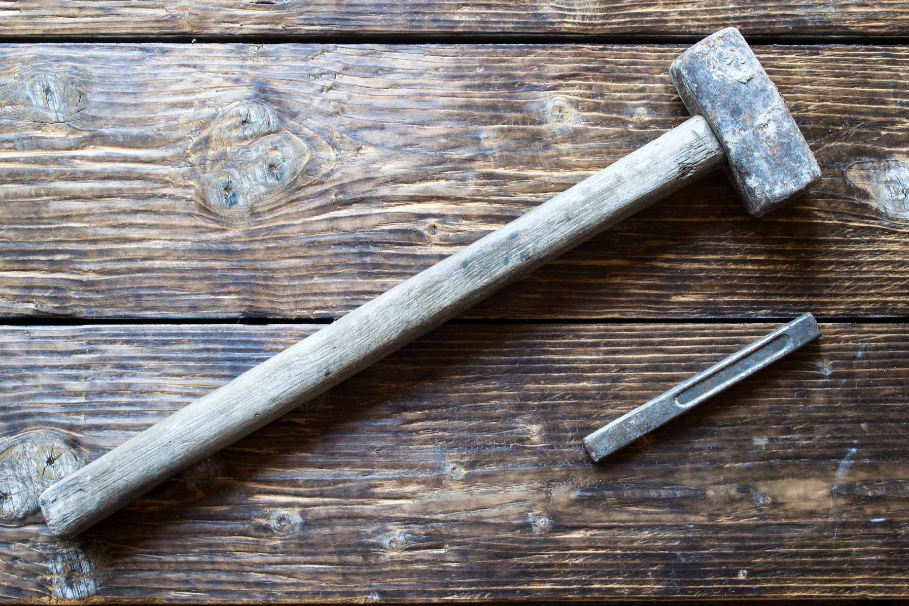 A sledge hammer on a wooden table.